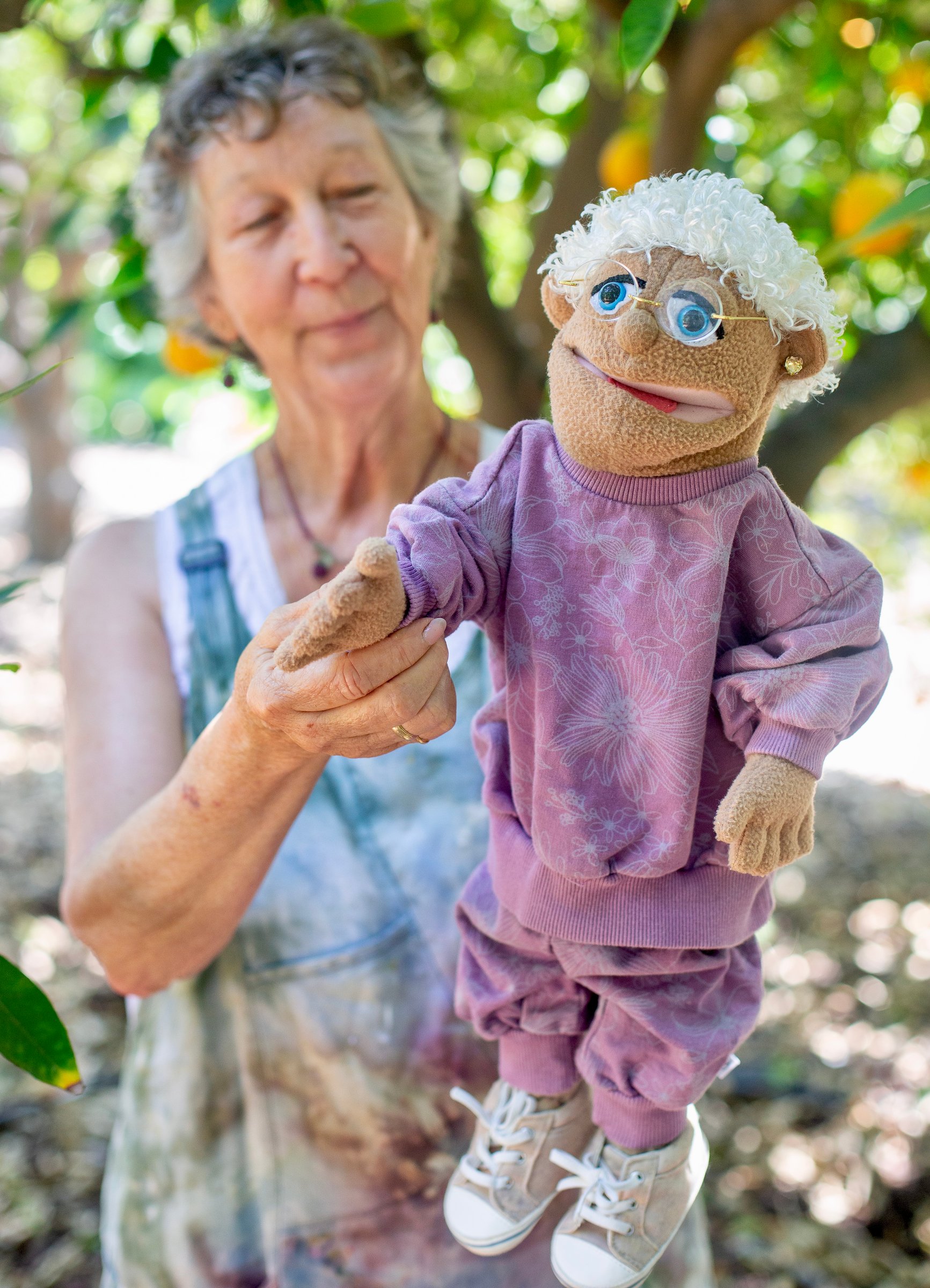 Carrie Elderberry holding a grandmother puppet in her garden
