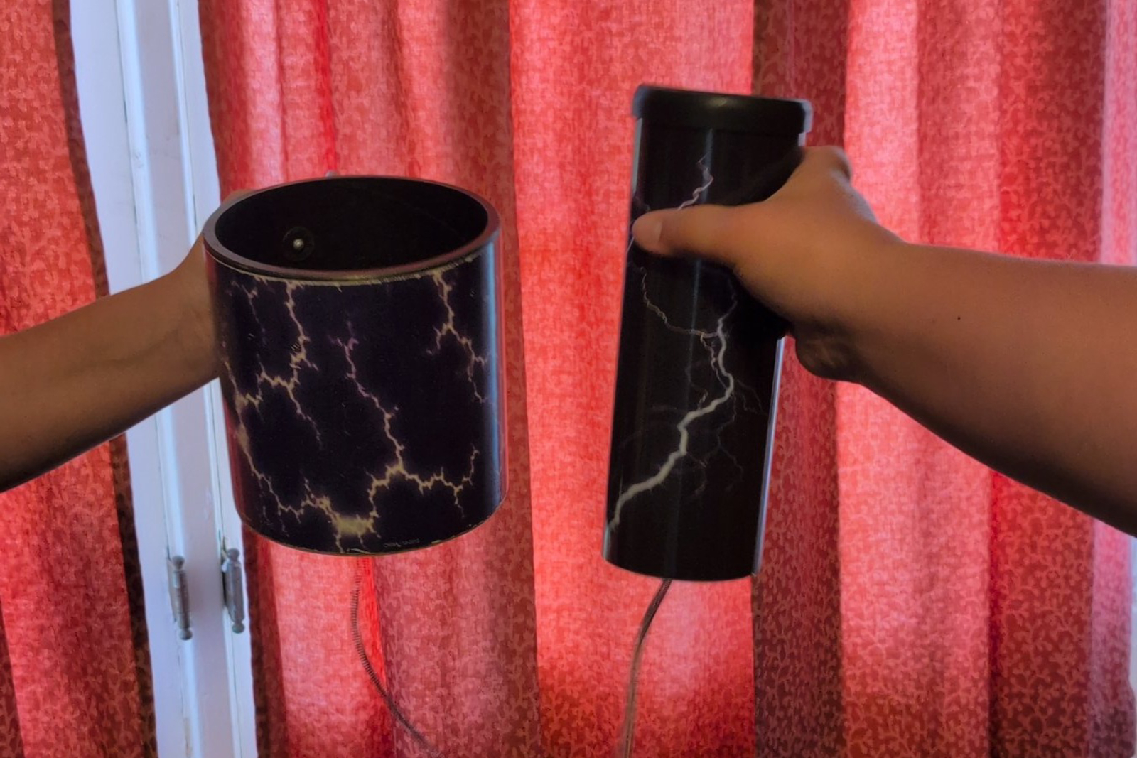 Hands holding thunder tubes used as sound effects